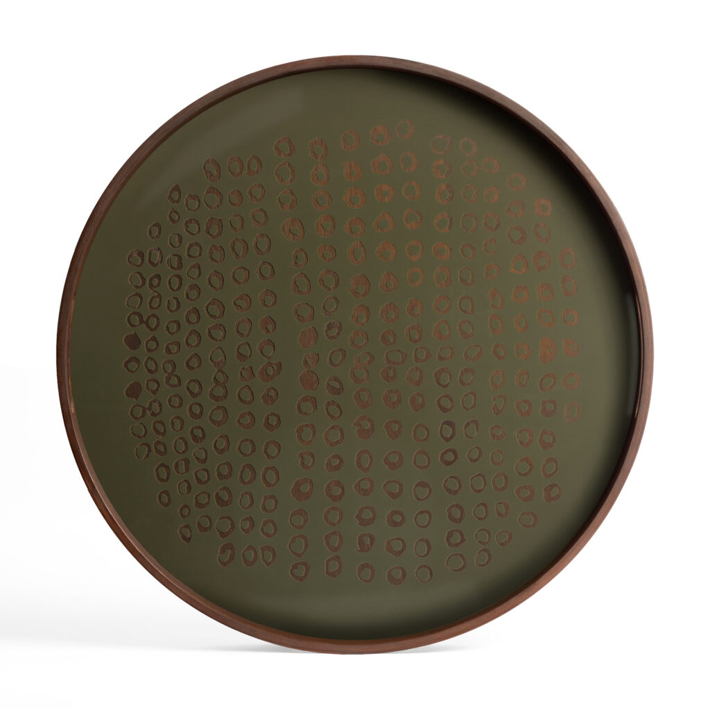 Le plateau en verre Seconde Nature Moss - rond - S présente une surface vert foncé avec un motif de points circulaires abstraits et un bord marron foncé.