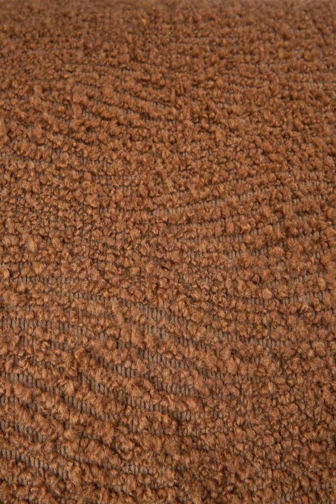 Gros plan d'un tissu marron texturé avec un motif de tissage en boucle, rappelant la cannelle.