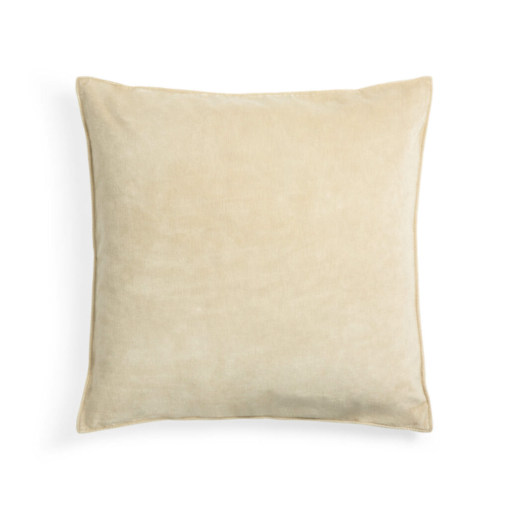 Un coussin carré beige 50x50x15, en velours doux, sur un fond blanc avec une touche de cannelle.