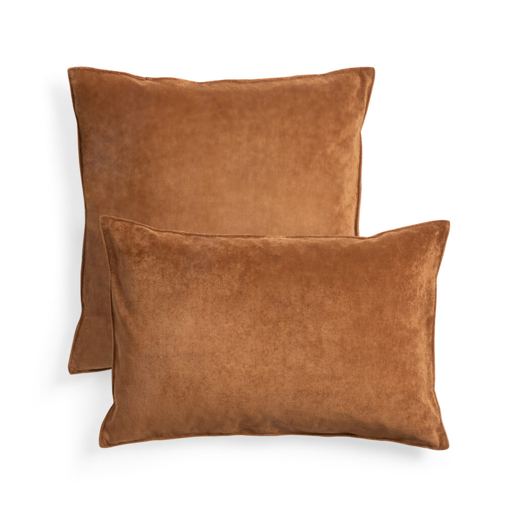 Deux coussins rectangulaires marron, l'un légèrement plus grand et placé derrière l'autre, se détachent sur un fond blanc. Le coussin principal mesure 50x50x15, ajoutant une touche de charme couleur cannelle proche d'un luxueux coussin en velours.