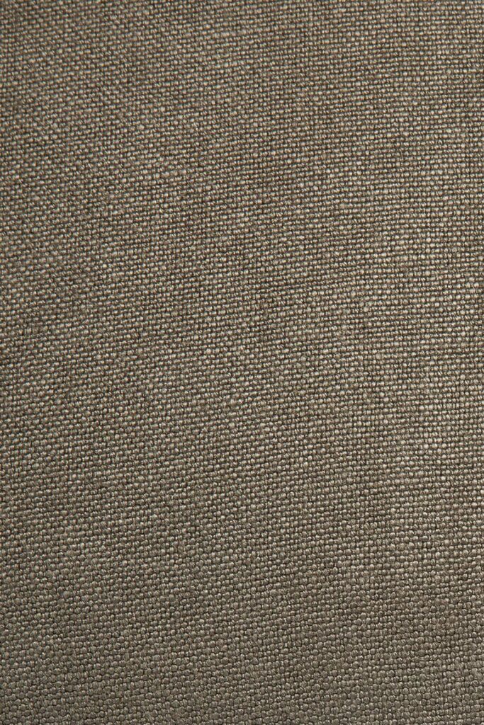 Vue rapprochée d'une surface en tissu beige texturé montrant son motif tissé, parfait pour un coussin Lin élégant ou comme ajout élégant à votre décoration intérieure.