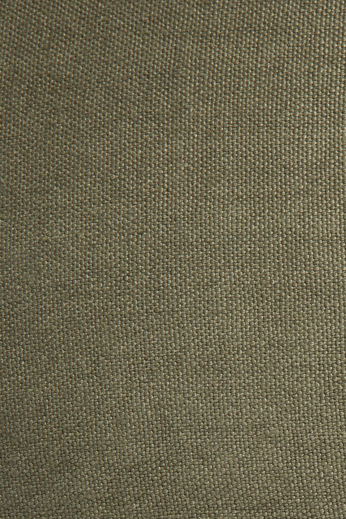 Une vue rapprochée montre le motif tissé du coussin Lin de couleur vert olive. Le tissu, rappelant un coussin Lin, présente une texture légèrement rugueuse avec de petits détails de forme carrée.