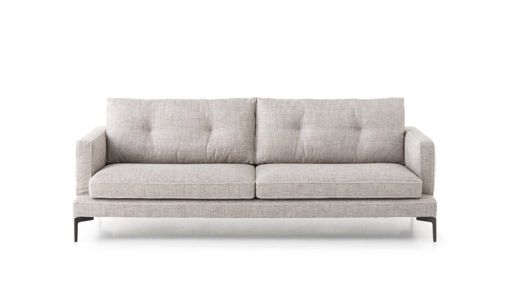 L'Expo-Canapé l'Essentiel 220 A est un canapé moderne en tissu gris clair avec deux coussins d'assise, trois coussins de dossier, des accoudoirs droits et des pieds en métal noir, présentés sur un fond blanc.