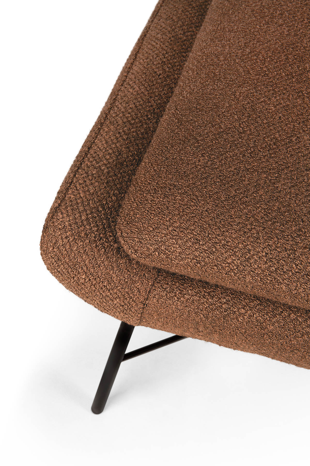 Gros plan d'un coussin rembourré texturé marron sur le Repose-pieds Barrow, doté de pieds en métal noir, sur fond blanc.