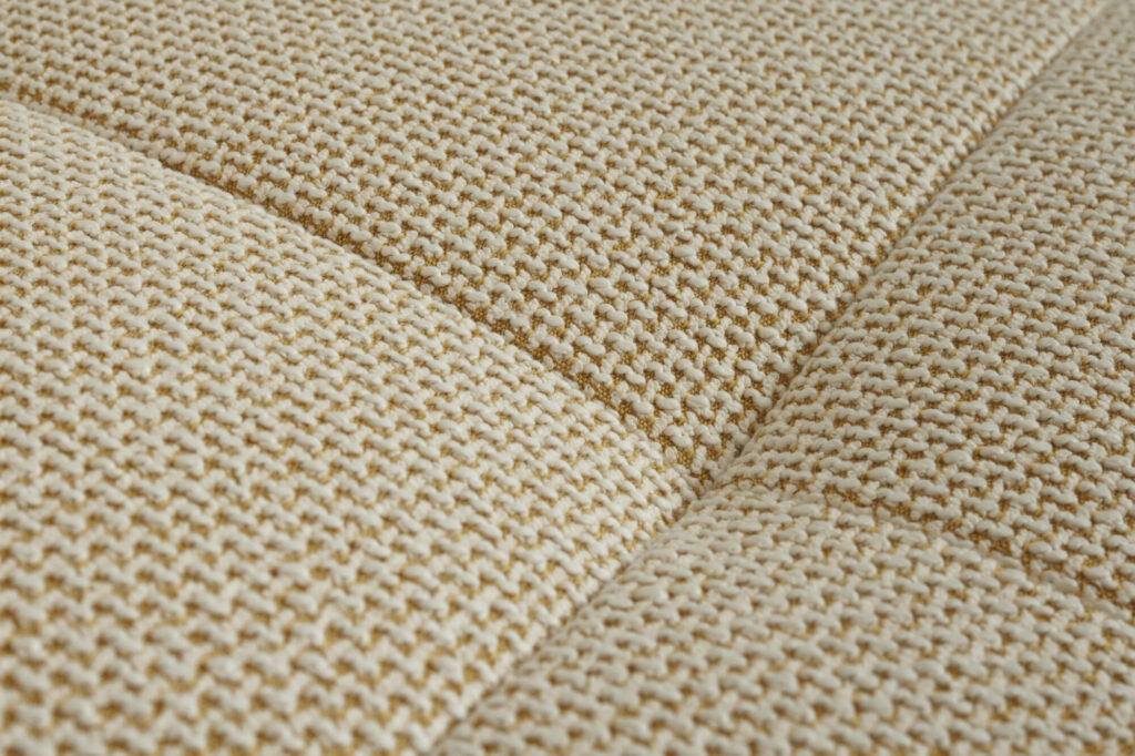 Zoom sur le canapé 2 places Quilton Lift avec piètement en chêne laqué wb en tissu Tartaglia Ocre White présentant un motif texturé et entrecroisé.