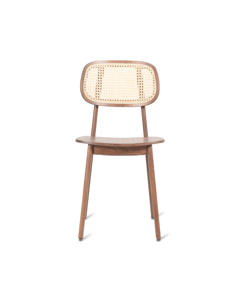 La Chaise Titus, fabriquée en bois de tabac teinté hêtre, présente un dossier en rotin tressé et des pieds inclinés, vus de face sur un fond blanc.