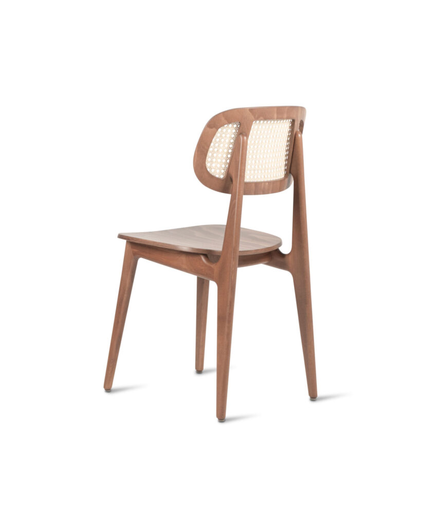 La Chaise Titus est une chaise en bois avec un dossier courbé, présentant un design en rotin tressé et une finition tabac teinté.