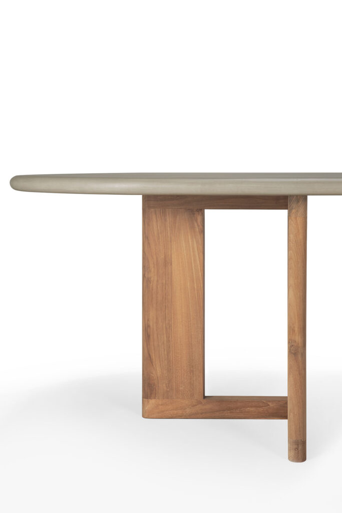 Gros plan de la table à manger d'extérieur Trestle avec un plateau rond gris clair et des pieds en bois au design minimaliste.
