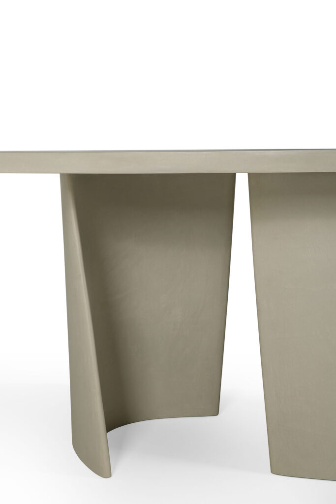 La table à manger d'extérieur ovale Canyon est une pièce beige moderne avec une base géométrique unique, des surfaces lisses et des lignes courbes pour un look élégant, parfait pour tout environnement extérieur.