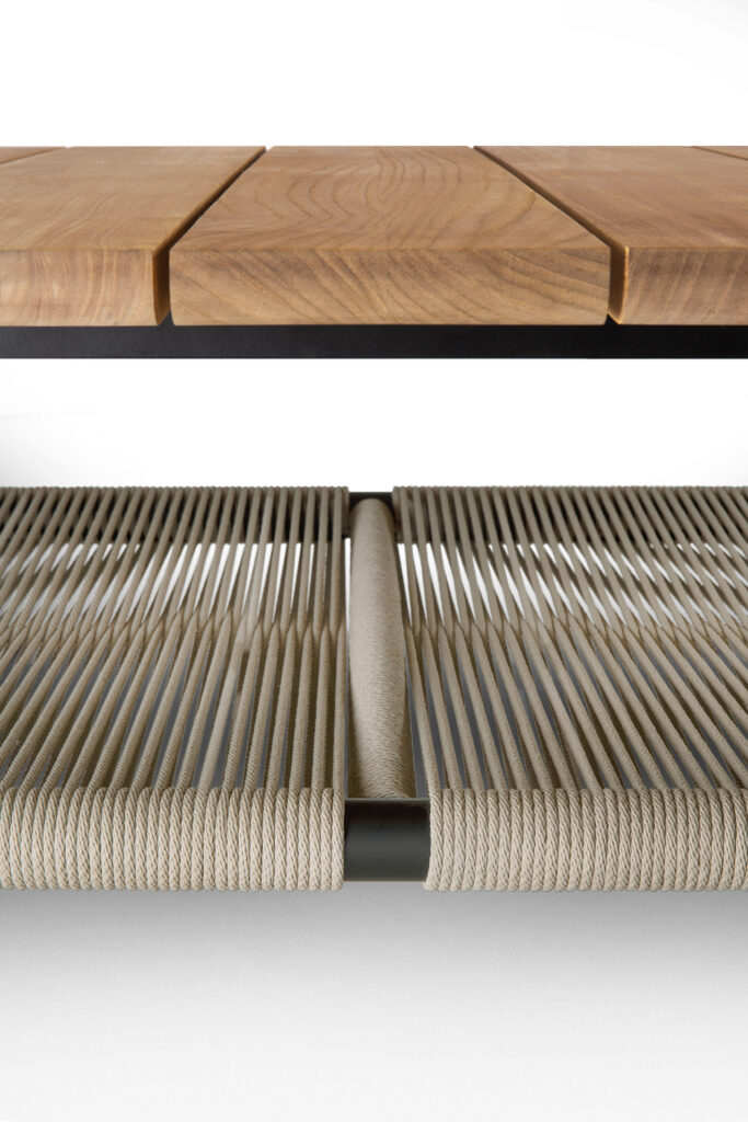 La table basse d'extérieur Corbey est dotée d'un plateau à lattes en bois et d'une étagère en corde tressée, tous deux soutenus par un cadre en métal noir. Ce design élégant ajoute du style et de la fonctionnalité aux patios ou aux espaces de jardin.