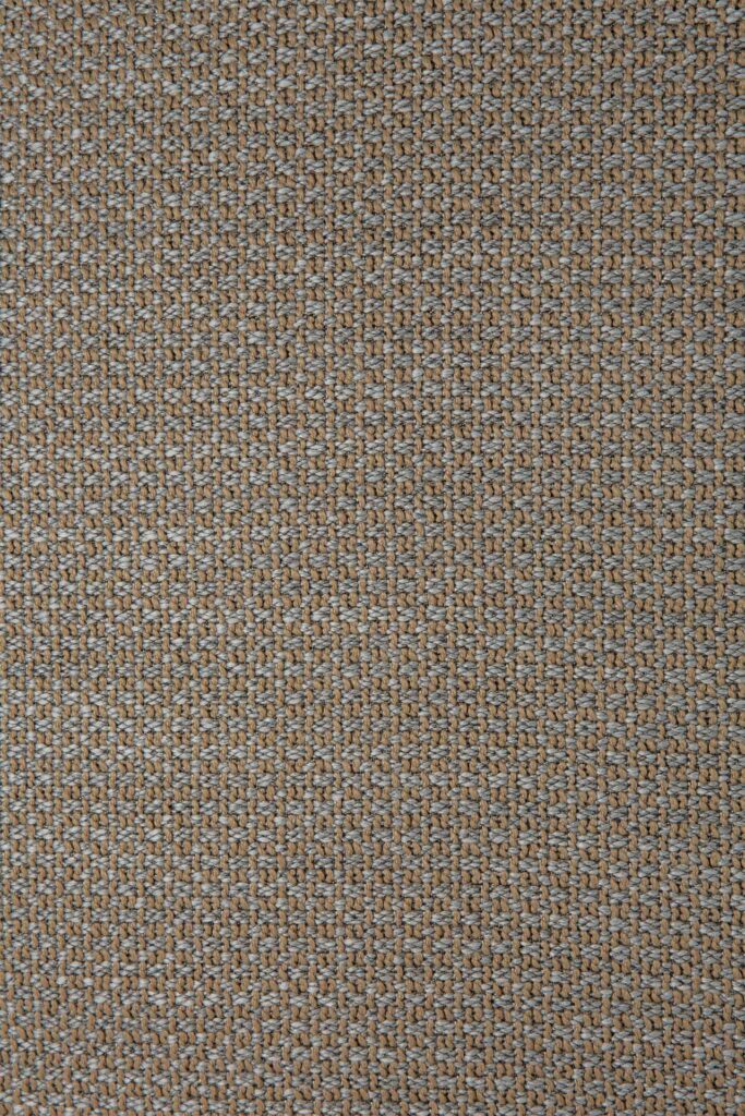 Gros plan d'un tissu tissé rappelant le doux tourbillon d'un beignet, présentant un motif serré et uniforme dans des tons beiges et marron clair apaisants.