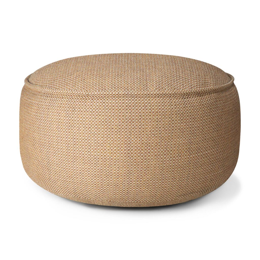 Un pouf rond en tissu beige avec une texture tissée rappelant un pouf de jardin couleur marsala est placé sur un fond blanc uni.