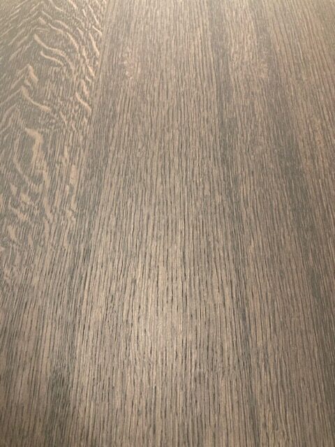 Gros plan sur la surface de l'Expo - Table Corto, avec une finition brun clair et des veines de bois visibles, idéale pour les stands d'exposition.