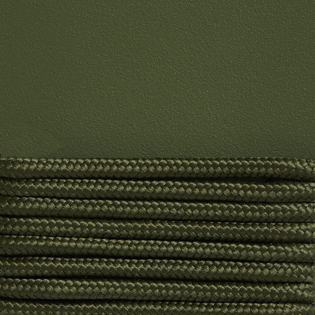Une surface verte texturée avec des rangées parallèles soigneusement empilées de corde verte tressée en bas, rappelant le design complexe trouvé dans une chaise longue Palissade CORD.