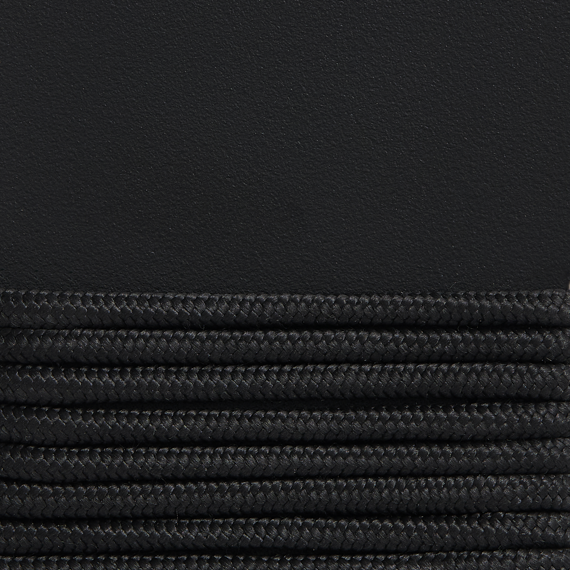 Gros plan sur un tissu plissé noir et une surface texturée, rappelant les motifs retrouvés sur une chaise longue Palissade CORD, ajoutant une touche élégante.