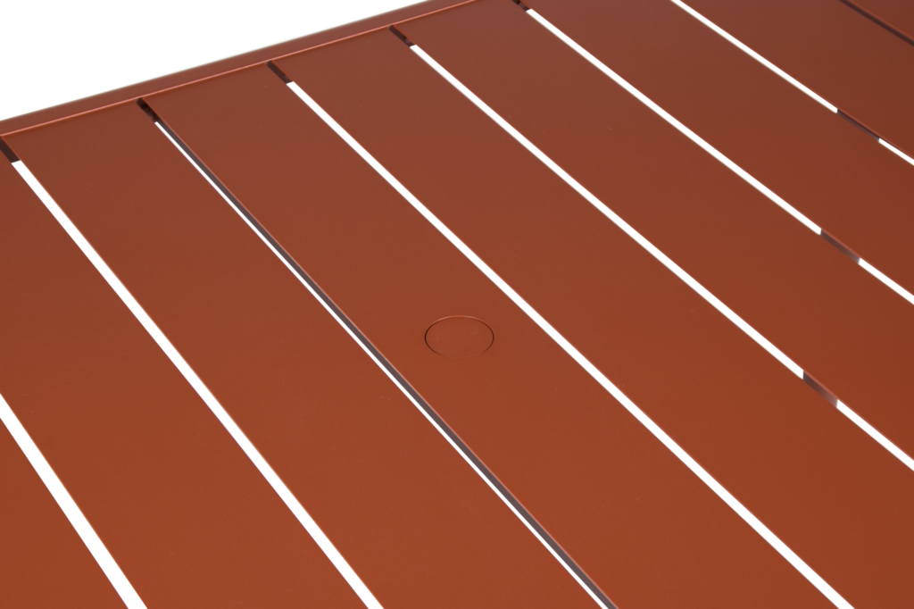 Vue rapprochée d'une surface à lattes brunes, probablement une Table Luxembourg en Bleu Maya, avec des lignes horizontales régulièrement espacées et un petit détail circulaire au centre.