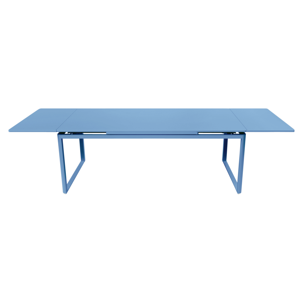 Une longue table rectangulaire Tonka bleu clair avec une surface plane et des pieds en métal minimalistes, vue de côté, apporte une touche d'élégance légère de Biarritz dans n'importe quel espace.