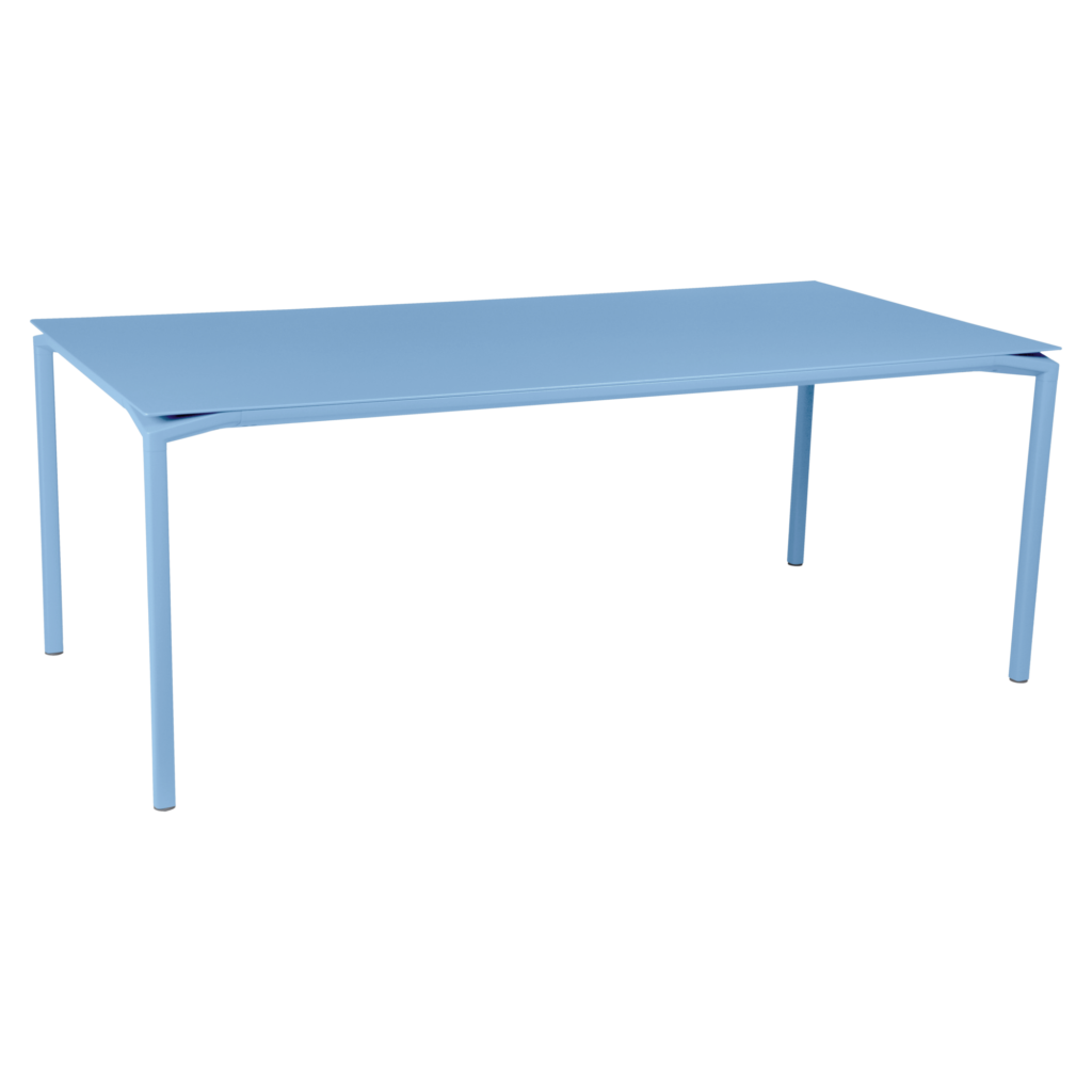 La table Calvi en Bleu Maya présente un design rectangulaire simple avec quatre pieds droits et une surface plane, mesurant 195 x 95 cm, présentée sur un fond blanc.