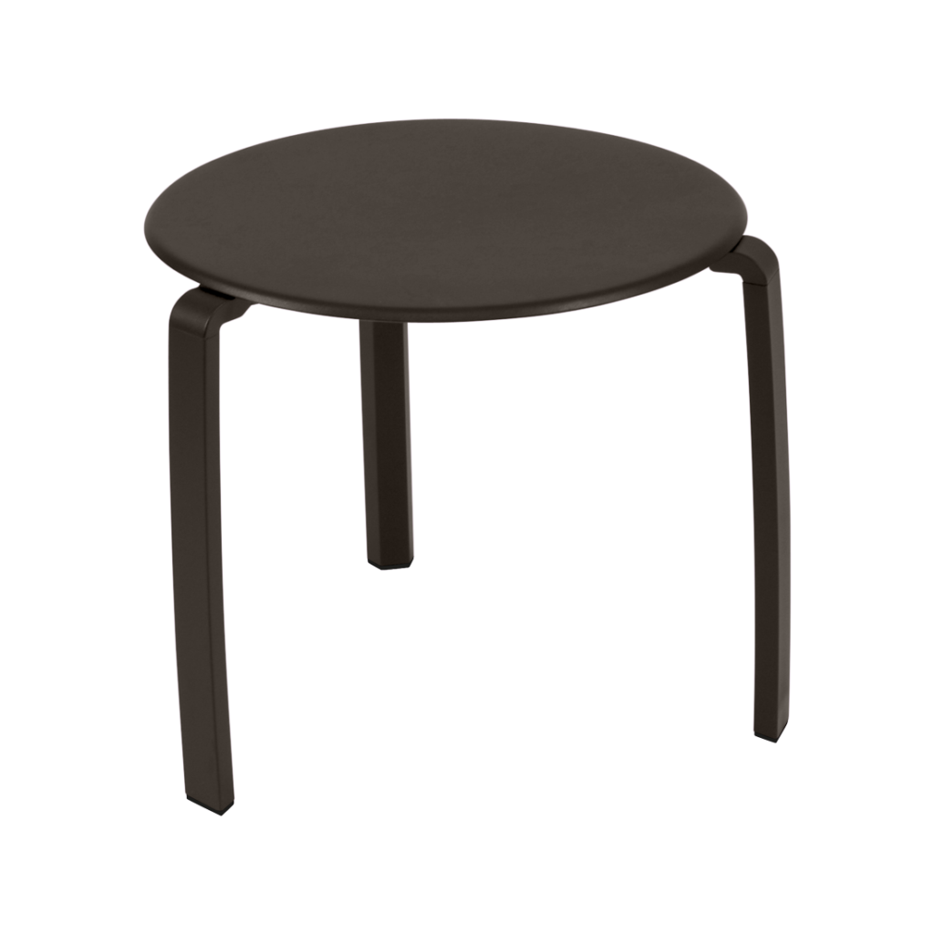 Une table basse ronde, noire, à trois pieds est représentée sur un fond violet clair.