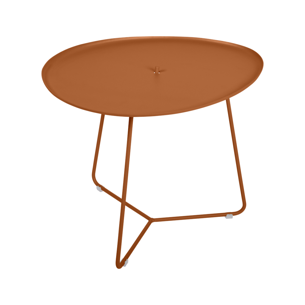 Table basse Cocotte ronde couleur rouille, dotée d'un plateau peu profond et de trois pieds métalliques fins et inclinés, sur fond beige clair. Des touches de Bleu Maya apportent une touche raffinée à sa silhouette moderne.