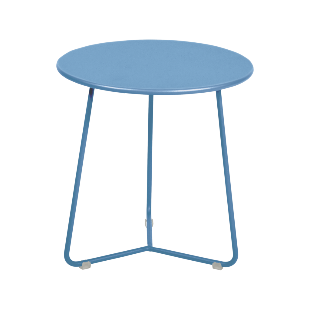 Une petite table ronde en métal Bleu Maya avec des pieds fins et un design simple, sur un fond uni.