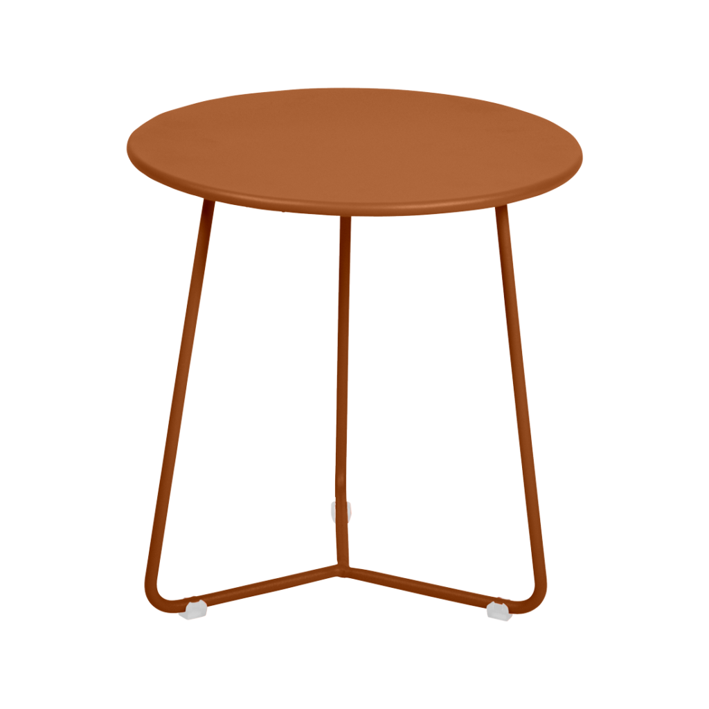 Une table d'appoint ronde en métal marron Cocotte à trois pieds fins se dresse sur un fond beige clair uni.