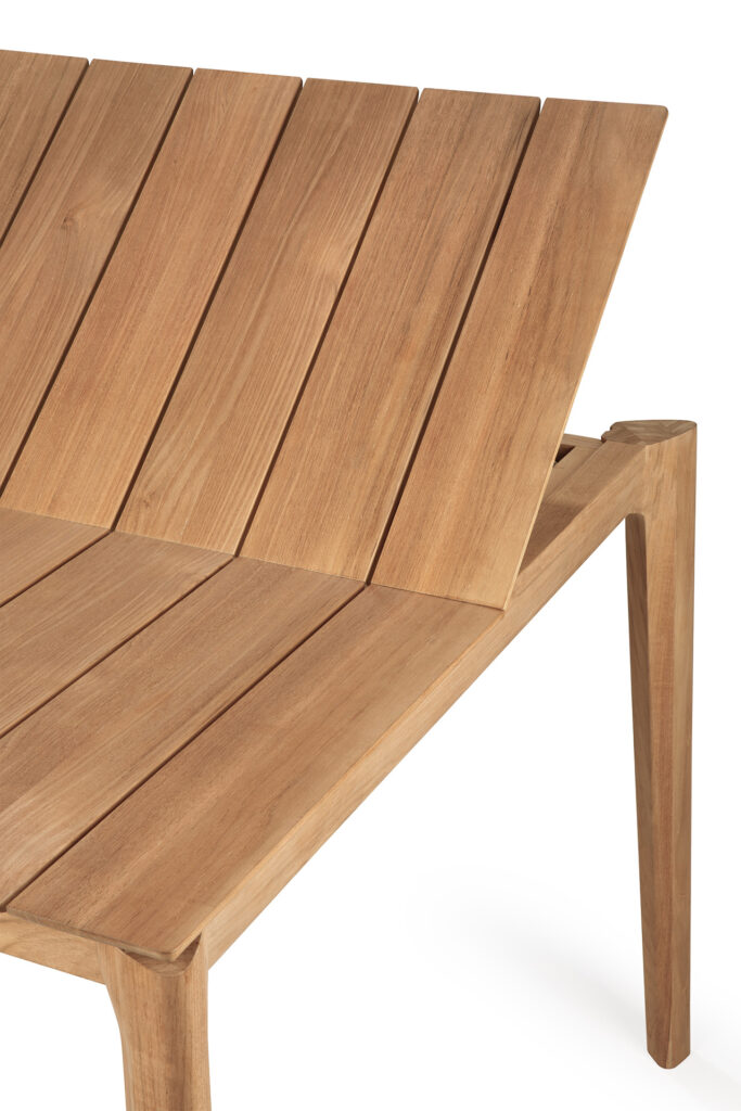 Vue rapprochée d'un banc en bois moderne avec un siège et un dossier à lattes, présentant des lignes épurées et une construction minimaliste en teck magnifiquement fini, parfait pour s'associer à votre table de jardin.