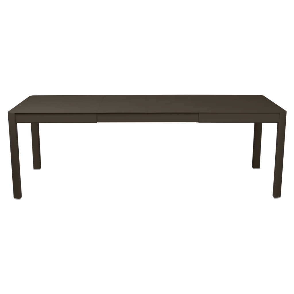 Une longue table rectangulaire Ribambelle extensible à six pieds, de couleur marron foncé, se détachant sur un fond violet clair.