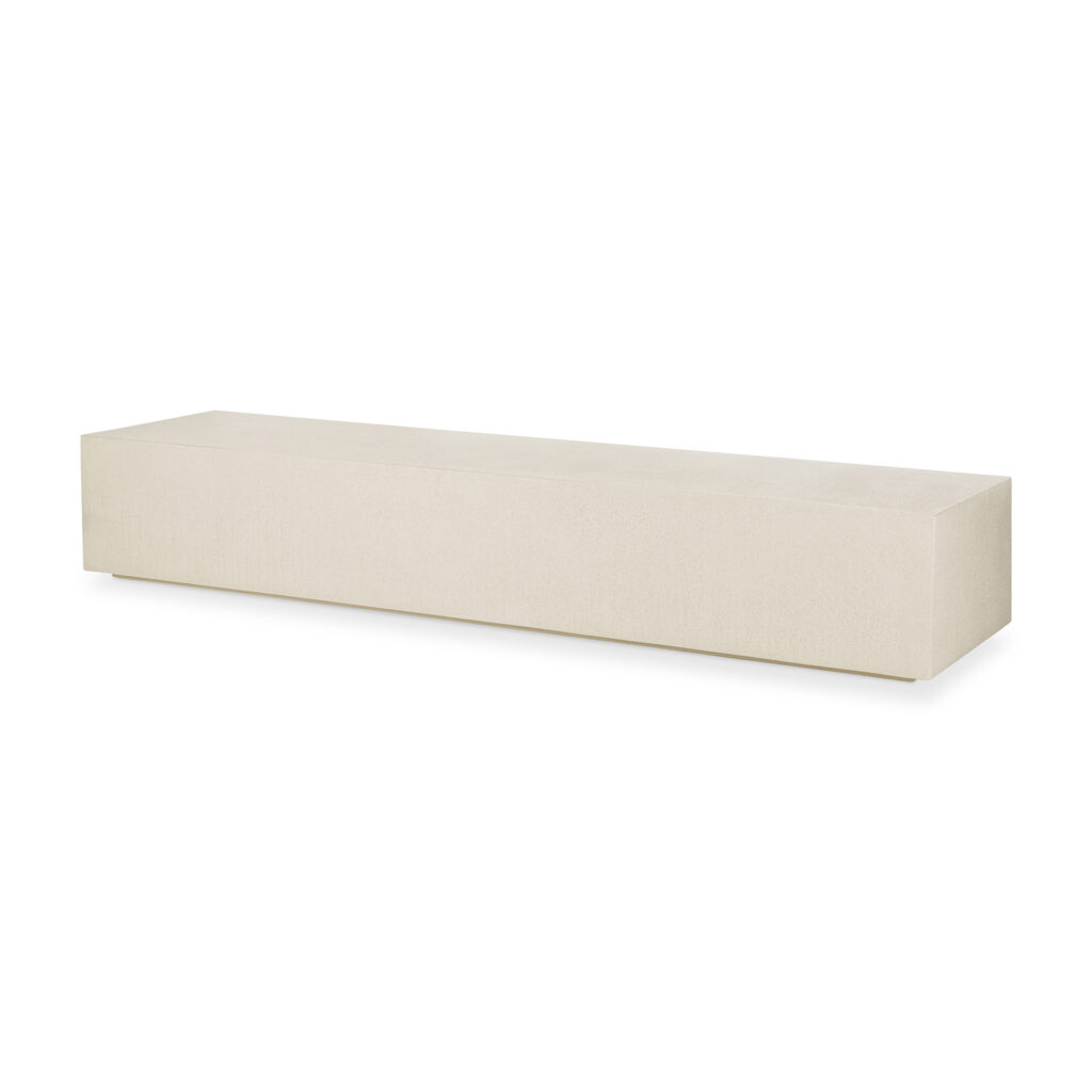 Un banc rectangulaire de couleur crème, aux lignes épurées et au design minimaliste, repose élégamment sur un fond blanc et s'associe parfaitement à l'étagère au sol Elements pour des solutions de rangement modernes.