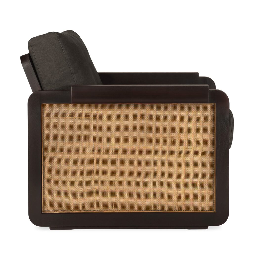 Vue latérale de la chaise longue Panel, avec son cadre en bois foncé, ses coussins noirs et ses panneaux en rotin tressé sur les accoudoirs et la base.