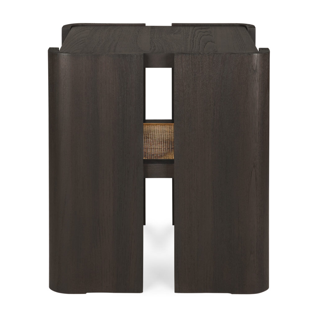 La table d'appoint Panel est un tabouret en bois foncé avec des côtés incurvés, des fentes verticales et un siège en rotin visible à travers une ouverture rectangulaire à l'avant. Elle est parfaite comme pièce d'appoint distinctive.