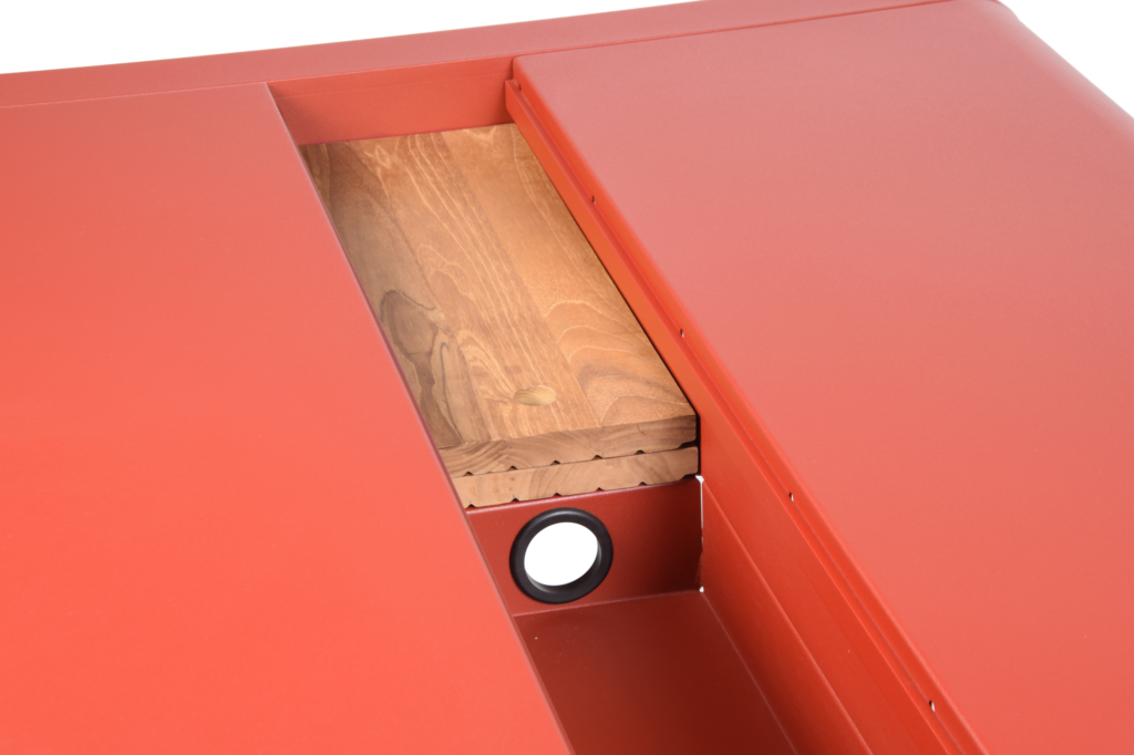 Vue rapprochée d'une structure en métal rouge avec un insert en bois et un trou circulaire noir dans la partie inférieure, parfait pour le rangement ou pour accentuer votre configuration de table Bellevie.