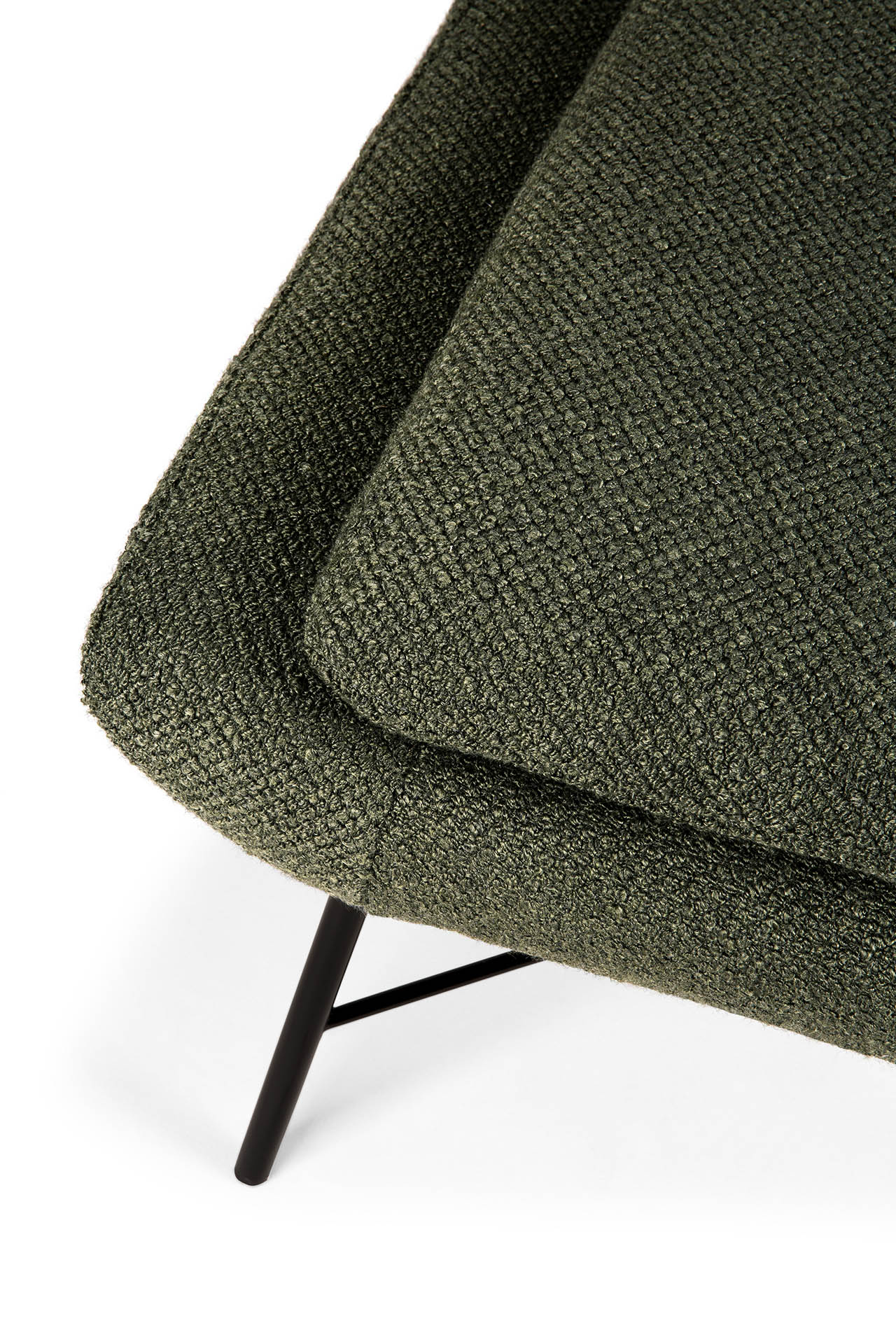 Vue rapprochée d'une chaise Barrow rembourrée texturée vert pin avec un coussin, des pieds en métal noir et un repose-pieds invitant.
