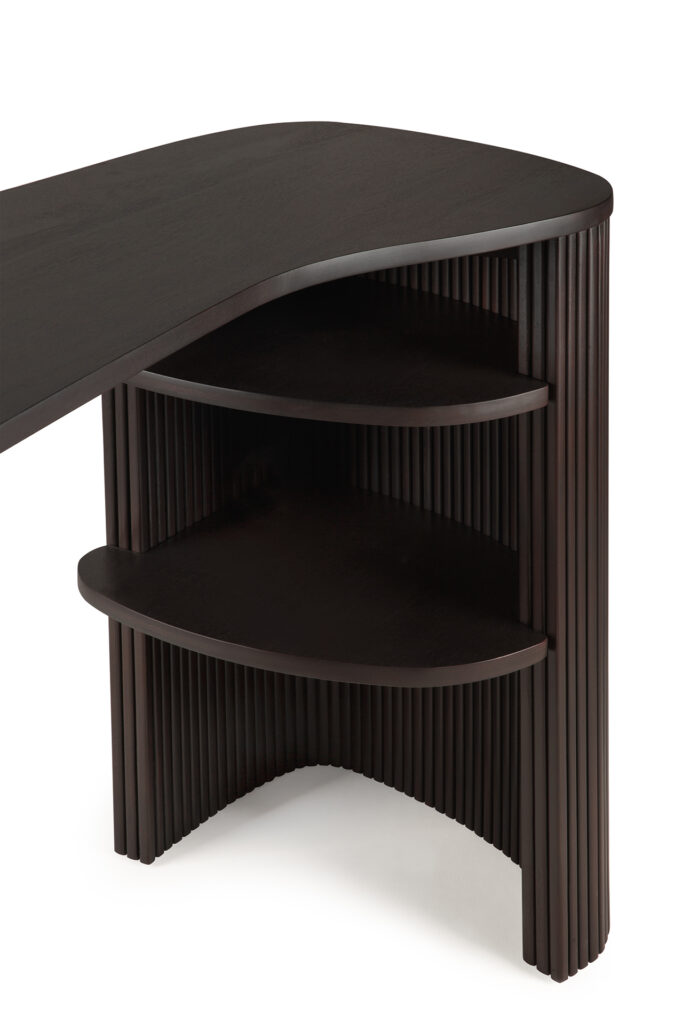 Le bureau Roller Max a une finition en bois foncé, des bords incurvés, deux étagères ouvertes et un motif vertical nervuré sur un côté.