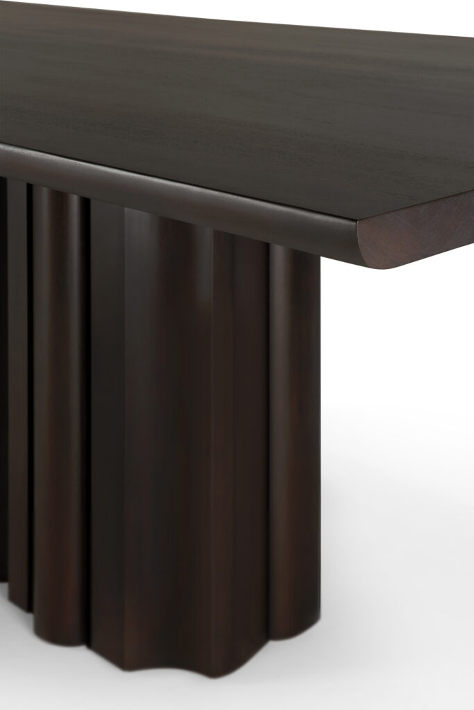 Un gros plan de la table de salle à manger Sequence met en évidence son plateau rectangulaire lisse en bois foncé et son piètement ondulé sculpté de manière unique.
