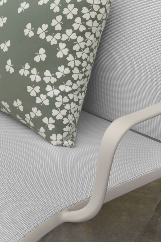Gros plan sur la chaise Cadiz en maille gris clair avec un coussin vert à motif de trèfle blanc, conçue pour compléter votre Banquette duo Cadiz.