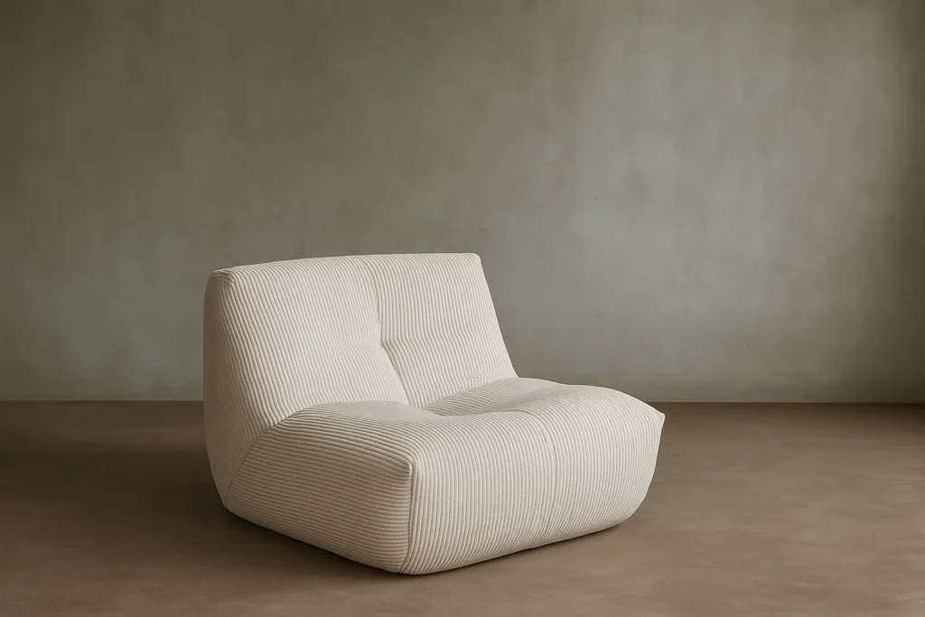 Le Cozy S - 1 place, un fauteuil moderne beige sans accoudoir avec un tissu texturé, est placé sur un sol brun uni contre un mur gris neutre.