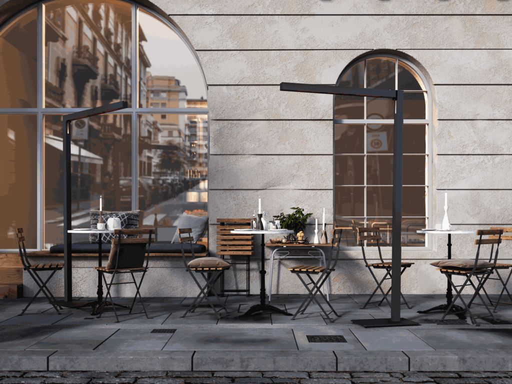 Les tables et les chaises d'un café en plein air sont éclairées par des fenêtres cintrées sur un trottoir pavé, idéal pour se détendre dans le confort de TWIG FS - Midnight (230V, EU) alors que les reflets de la ville illuminent la nuit.