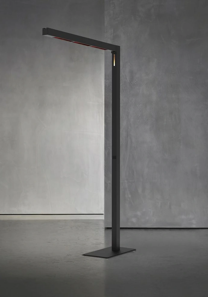 Le lampadaire TWIG FS - Midnight (230V, EU) présente un design noir minimaliste avec un bras à angle droit et une base plate, se détachant élégamment sur un mur gris texturé.