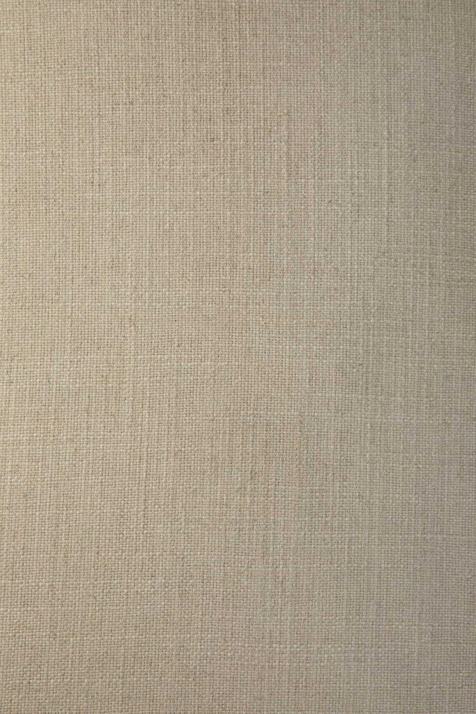Vue rapprochée d'une surface de tissu beige texturé avec un motif tissé uniforme, typique d'une chaise longue Weave de couleur os.