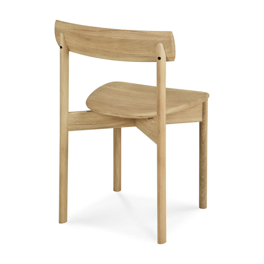 La chaise de salle à manger Risu se caractérise par son bois clair, son dossier incurvé et son assise inclinée. Représentée de dos sur fond blanc.