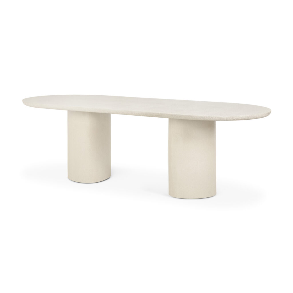 Table oblongue minimaliste avec une surface lisse de couleur claire et deux pieds cylindriques, mettant en valeur des éléments de table raffinés sur un fond blanc uni.