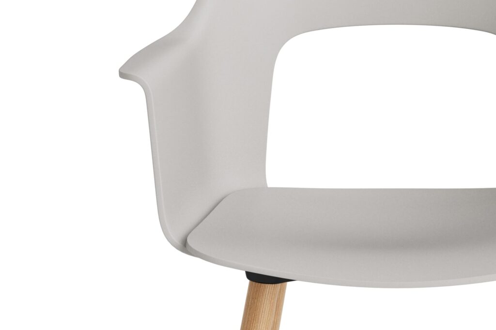Vue partielle d'une chaise moderne avec une assise en plastique gris clair, un accoudoir noir et un pied en bois chêne laqué, sur fond blanc.