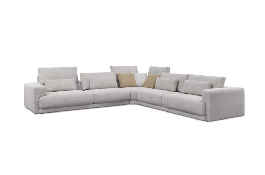 Le Canapé Willow [4z-Nzz-4z] - C25 Perfect Harmony est un grand canapé sectionnel gris clair en forme de L avec des dossiers bas et de multiples coussins, dont deux coussins marron clair, pour un confort élégant dans n'importe quel espace de vie.
