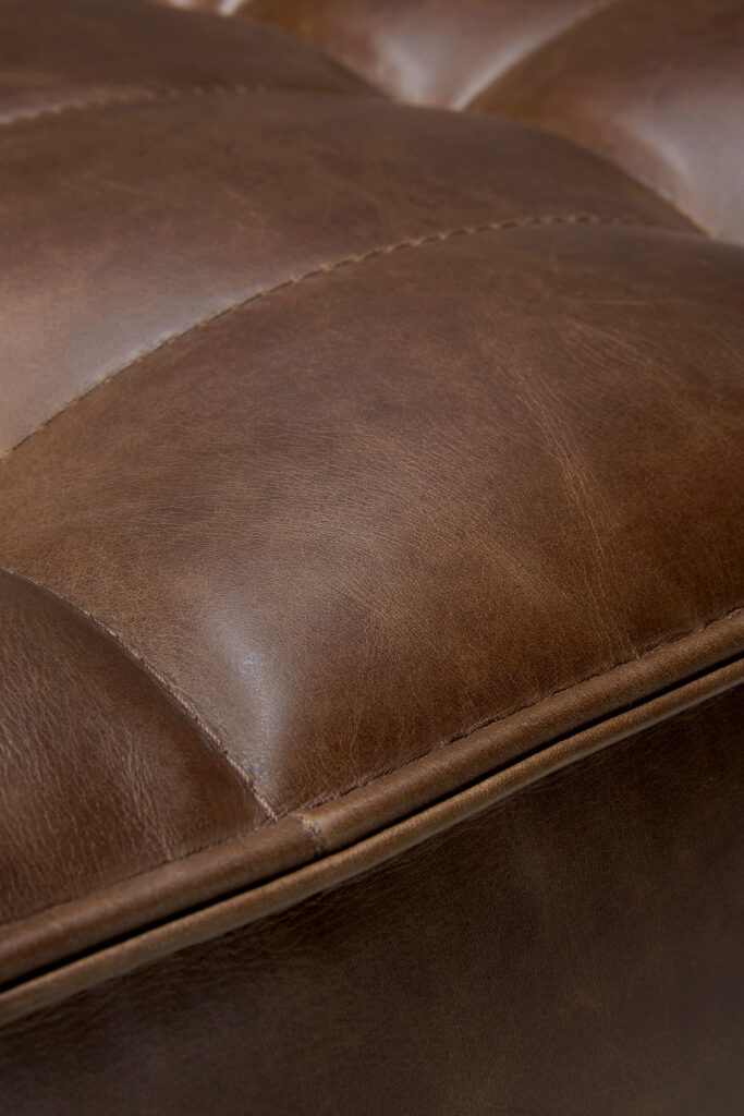 Gros plan sur un coussin Canapé N701 1 place en cuir aniline, dont les coutures détaillées et la texture luxueuse sont mises en valeur.