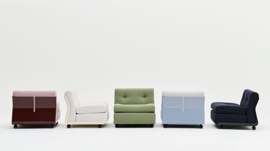 Cinq fauteuils sans accoudoirs rembourrés en rose, crème, vert, bleu clair et marine - rappelant l'Amanta 1 seater - sont disposés en rangée sur un fond blanc uni, mettant en valeur les options de tissu Tissu groupe 4.