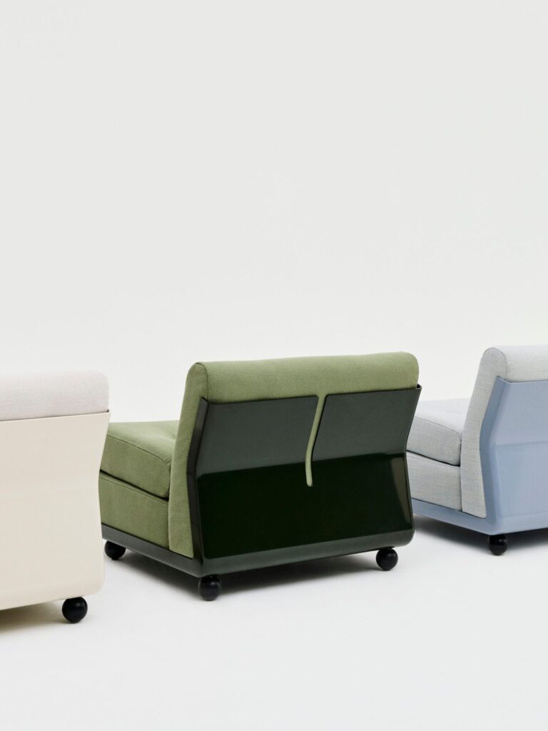 Trois fauteuils rembourrés, dont le fauteuil Amanta 1 place en Tissu groupe 3, sont dotés de dossiers brillants et de roues pivotantes. Des chaises beiges, vertes et bleu clair sont disposées côte à côte sur un fond blanc uni.