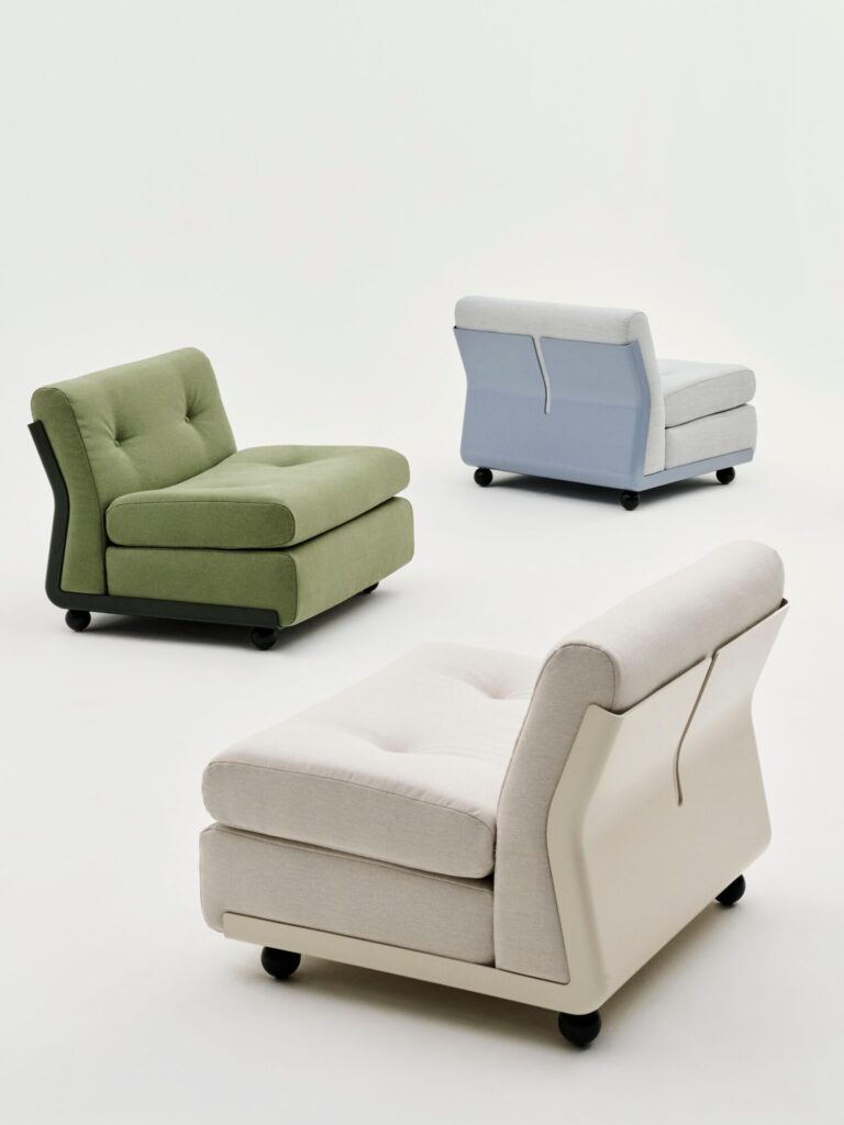 Trois chaises de salon modernes, dont une Amanta 1 place en tissu Tissu groupe 2, sont disposées sur un fond blanc uni, chacune présentant un profil bas, des coussins touffetés et des pieds noirs arrondis.