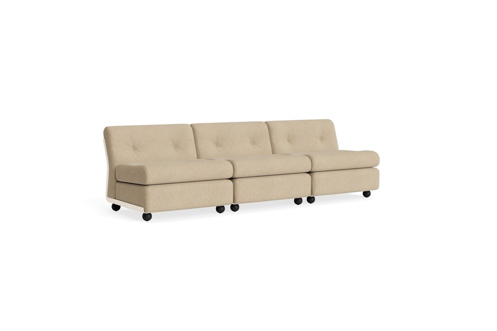 Le canapé Amanta 3 places est un canapé modulaire beige sans accoudoir avec des coussins touffetés et des roues pivotantes noires, revêtu de Tissu groupe 1, présenté sur un fond blanc.