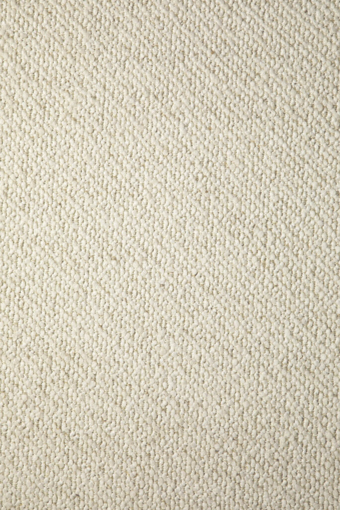 Gros plan sur le tissu texturé blanc cassé du canapé Contour 3pl., mettant en évidence son motif en relief, semblable à des galets, que l'on retrouve souvent sur les canapés contour modernes.